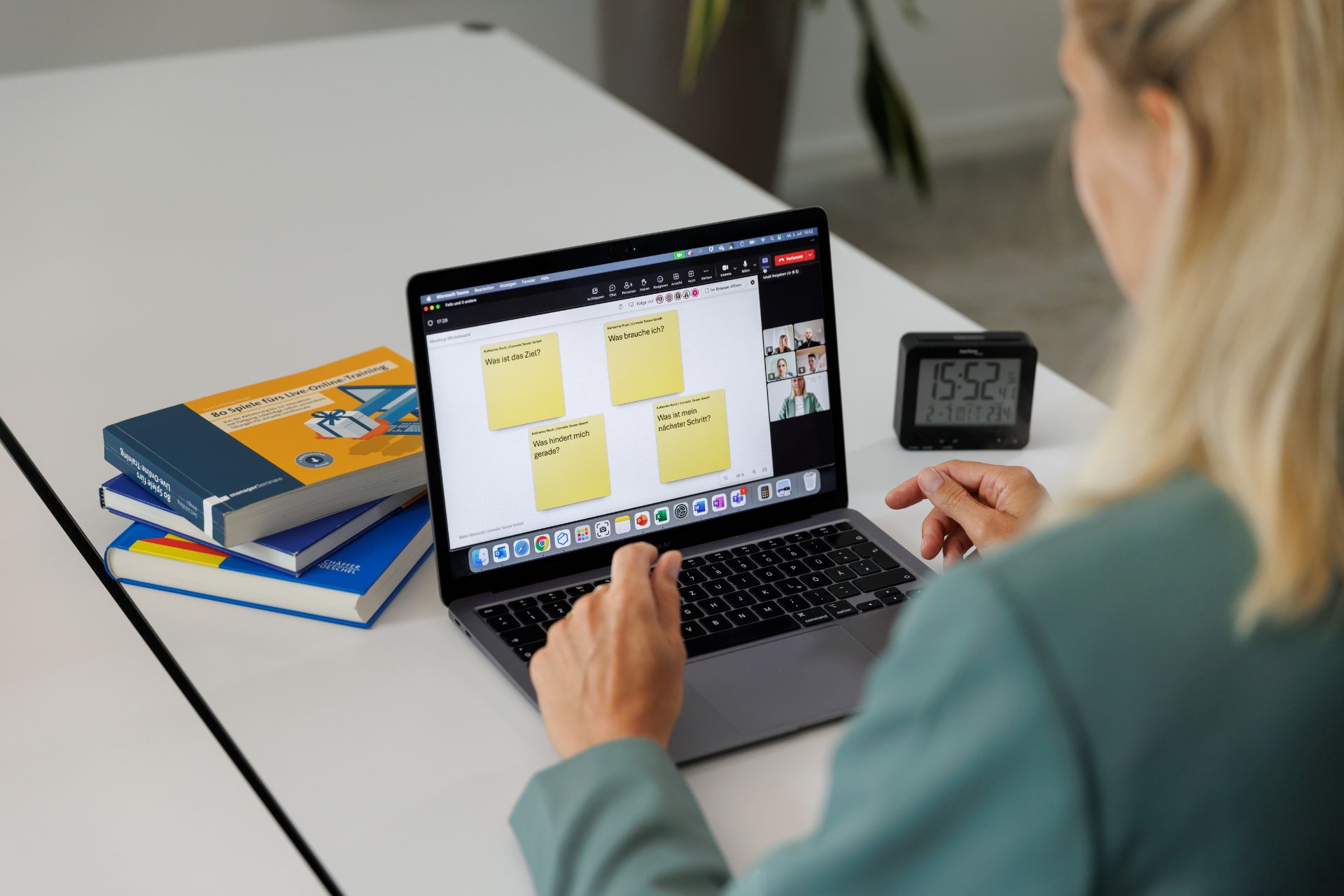 Person nimmt an virtuellem Gruppencoaching teil und arbeitet mit Reflexionsfragen und Videokonferenz am Laptop