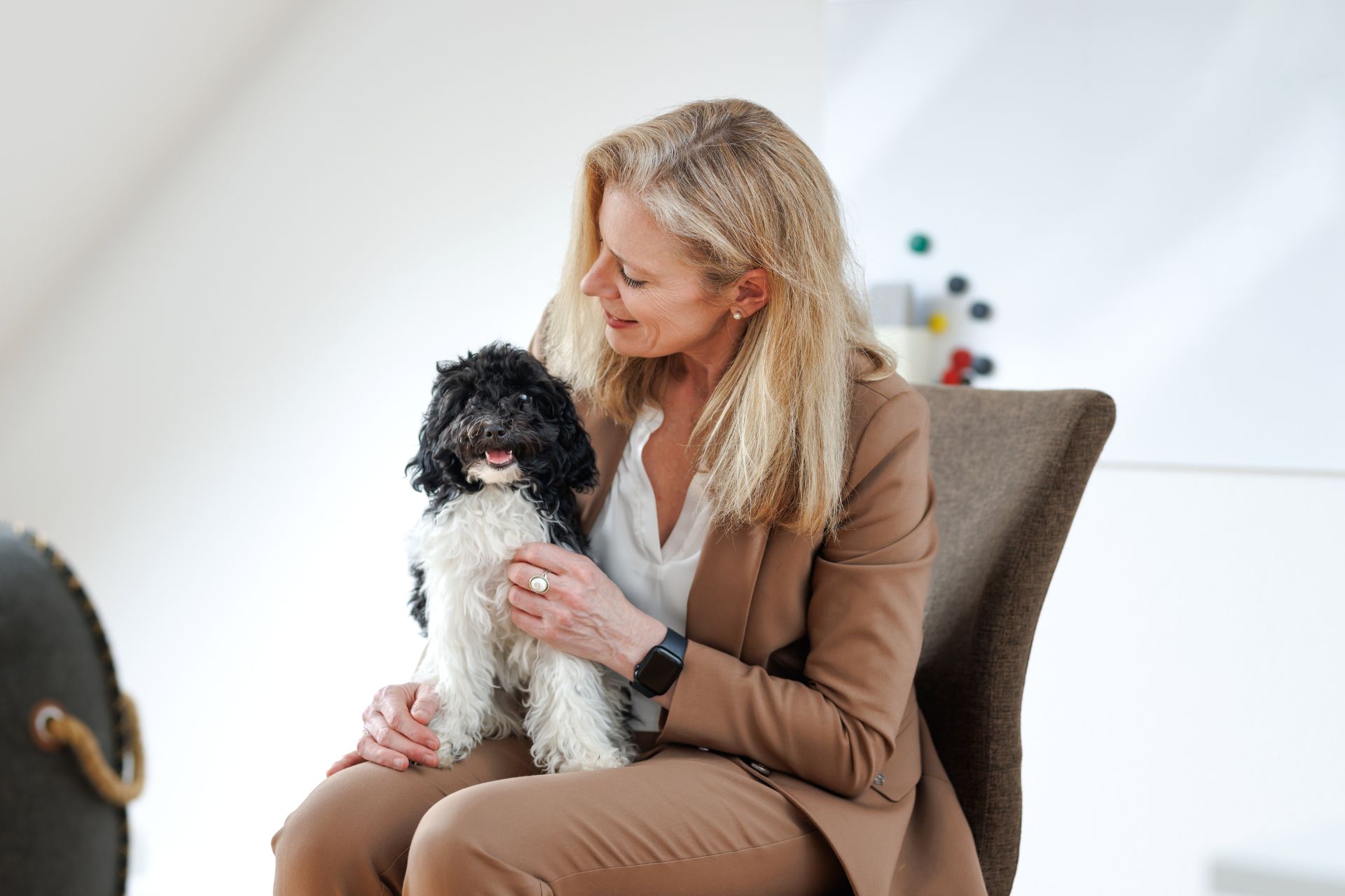 Cornelia Tanzer sitzt mit kleinem schwarz-weißen Hund auf dem Schoß